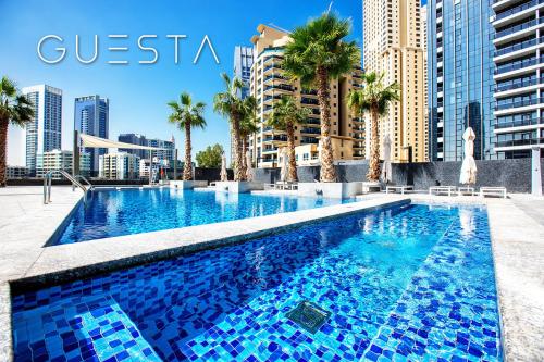 a swimming pool in a city with palm trees and buildings at Sparkle Tower, Dubai Marina in Dubai