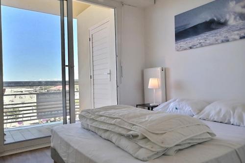 een slaapkamer met 2 bedden en een groot raam bij Lala Springs Anglet - Vue océan - WIFI - Balcon in Anglet