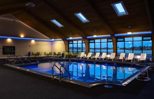 una gran piscina cubierta con sillas, mesas y ventanas en Seaport Resort and Marina, en Fairhaven