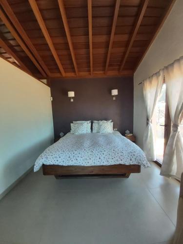 une chambre avec un lit et un plafond en bois dans l'établissement Casa El Peral, à Puntagorda