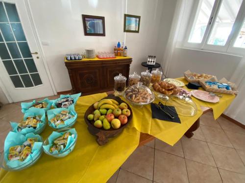une table avec plusieurs assiettes de nourriture dans l'établissement Helios Hotel, à San Teodoro