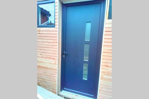 una porta blu sul lato di un edificio di STUDIO Jasmin & Jardin 1 à 2 pers à Villa Terra a Balma