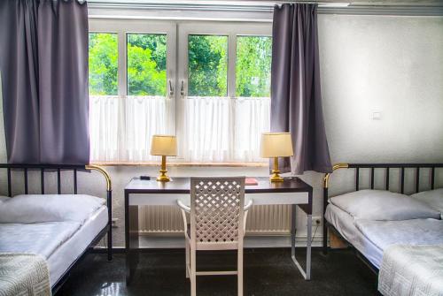 a bedroom with two beds and a desk with a chair at Ferienanlage Duhnen Haus 23 in Cuxhaven