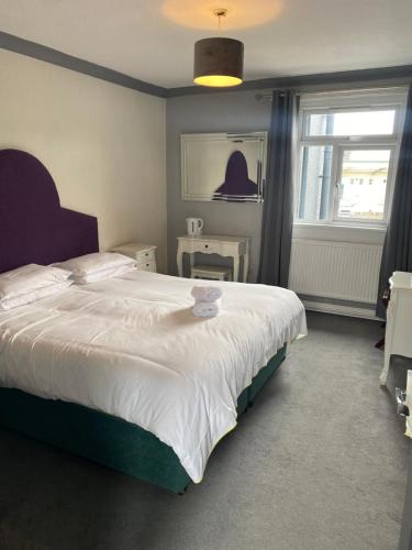 Un dormitorio con una gran cama blanca y una ventana en The Traxx Hotel, en Bangor