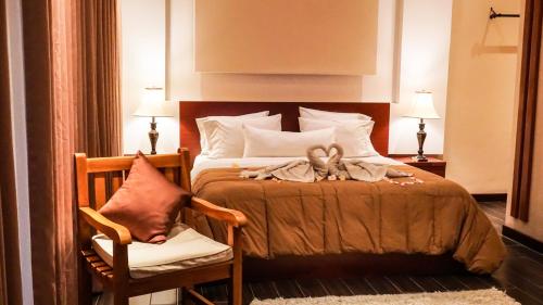 a bedroom with a bed with a chair and two towels at Muaya Villa in Jimbaran