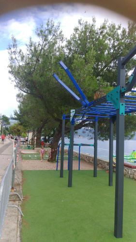 een park met blauwe structuren op het gras bij het water bij Apartment Pavica in Novi Vinodolski