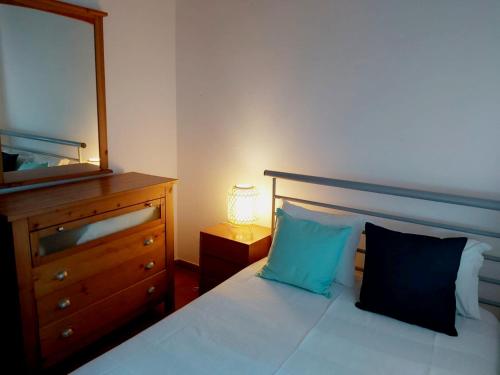 een slaapkamer met een bed, een dressoir en een spiegel bij The Beach House - Historic Center - Duna Parque Group in Vila Nova de Milfontes
