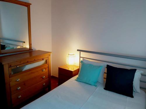 a bedroom with a bed with a dresser and a mirror at The Beach House - Duna Parque Resorts & Hotels in Vila Nova de Milfontes
