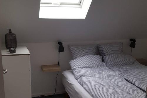 a bedroom with a bed with two pillows and a window at Elleholm in Odense