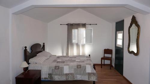 a bedroom with a bed and a window and a mirror at Ilha & Montanha - Turismo Rural in Santana