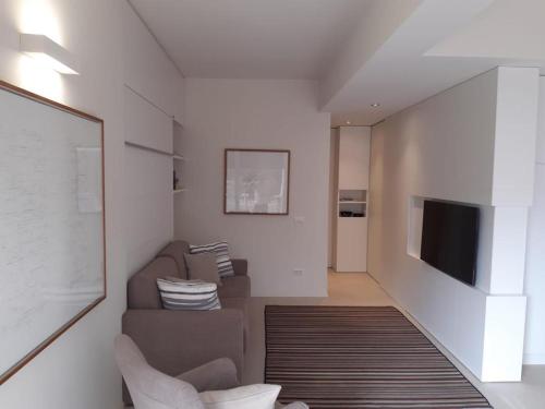 een woonkamer met een bank en een televisie bij Olivo House 2 in Portovenere