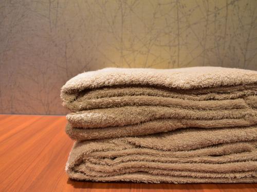 a pile of towels sitting on top of a wooden floor at Dormy Inn Premium Wakayama Natural Hot Spring in Wakayama
