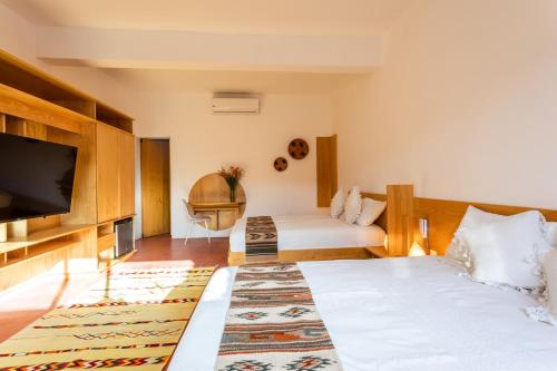 Habitación de hotel con 2 camas y TV de pantalla plana. en AYOOK en Oaxaca de Juárez