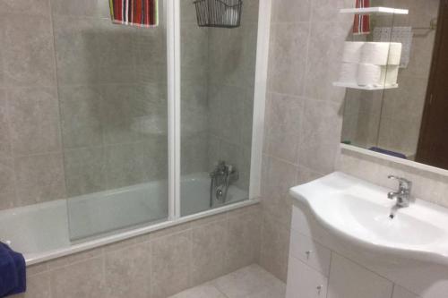 a bathroom with a shower and a sink and a tub at Charming Family Large Apartment in Bragança