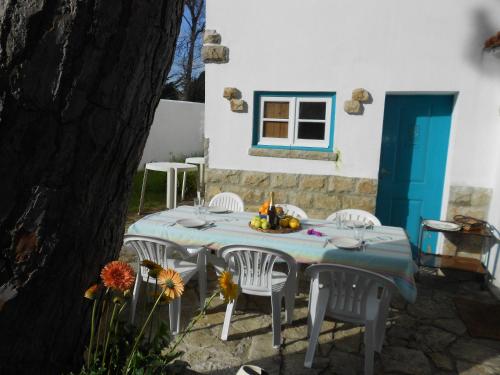 a table with white chairs and a blue door at Casa Turquesa in Sintra