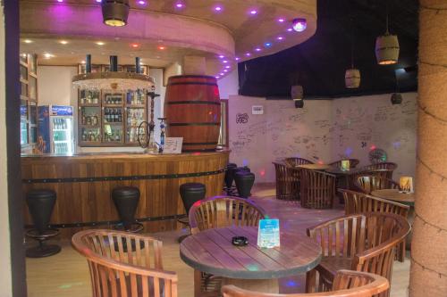 a restaurant with tables and chairs and a bar at Nice Place Resort in Dambulla