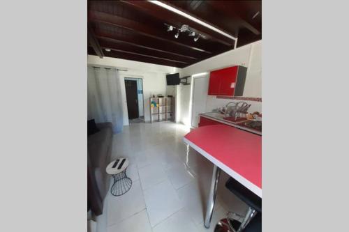 a kitchen with a red counter and a red counter top at La Kaz d'Évania in Sainte-Rose