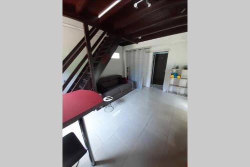 a living room with a couch and a red chair at La Kaz d'Évania in Sainte-Rose
