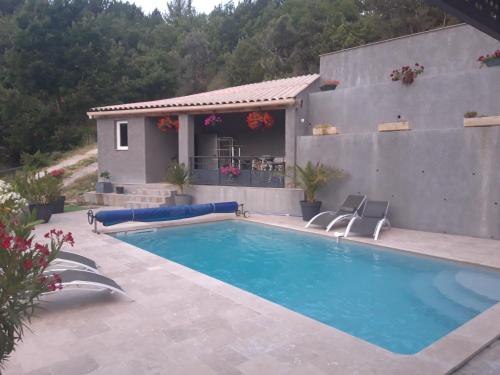 a swimming pool with two chairs and a house at Villabellevie in Bras-dʼAsse