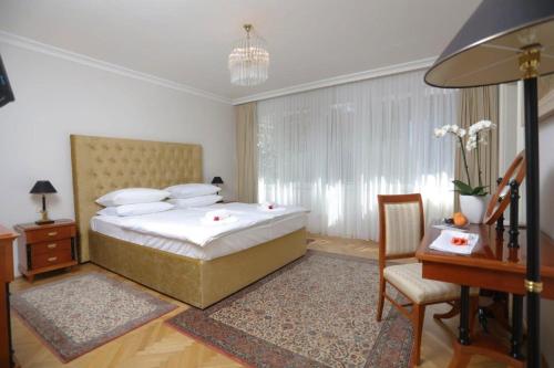 1 dormitorio con cama, mesa y escritorio en Vila Tartini, en Strunjan