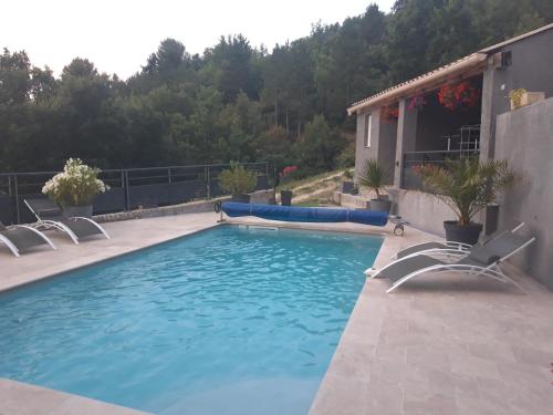 a swimming pool with two lawn chairs and an inflatable at Villabellevie in Bras-dʼAsse