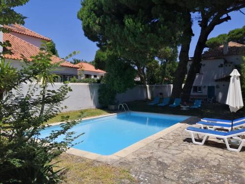 a swimming pool with a table and a chair and a umbrella at Casa Turquesa in Sintra