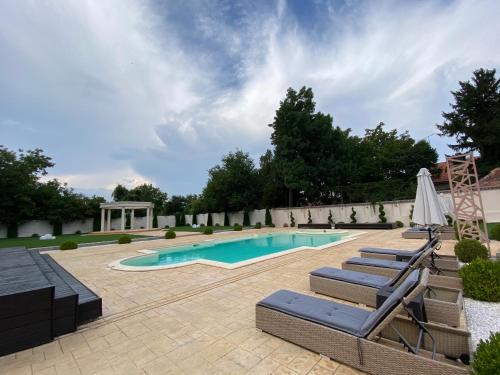 una piscina con sedie a sdraio e un patio con piscina di Hotel Bellavista Deta a Deta