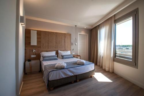 a bedroom with a large bed with a large window at Aqua Boutique Hotel in Castiglione della Pescaia