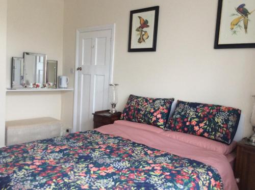 a bedroom with a bed with a colorful bedspread at Heatherdene House in Wimborne Minster