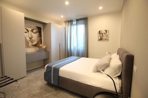 Casa Vacanze Residence Ideale Suites and Apartments في ألاسيو: غرفة نوم بسرير ودهان على الحائط