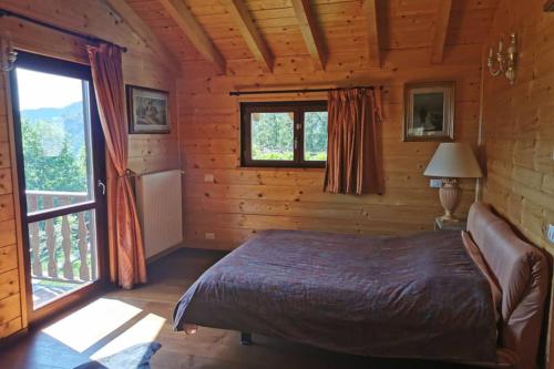 1 dormitorio con 1 cama en una cabaña de madera en Villetta Piemartin, en Saint Vincent
