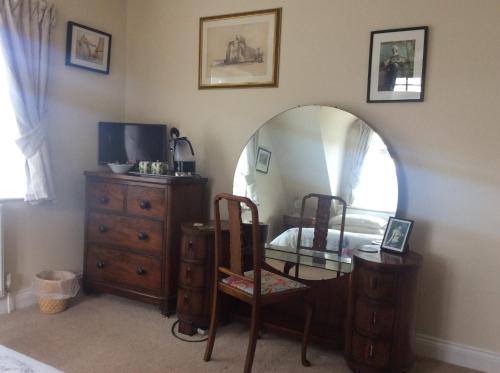 a bedroom with a mirror and a dresser and a bed at Heatherdene House in Wimborne Minster