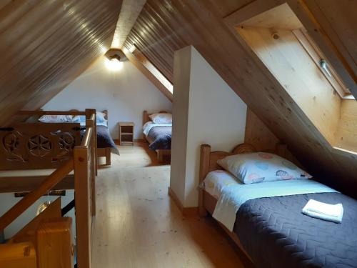 クルシュコフツェにあるApartament Modrzewiowy Rajのベッドルーム(ベッド2台付)が備わる屋根裏部屋です。