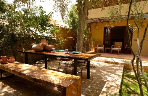 a patio with a table and a bench in a yard at Hotel Casa Terra in Villa de Leyva