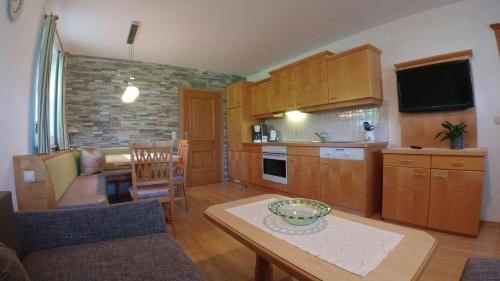 eine Küche und ein Wohnzimmer mit einem Tisch und einem Sofa in der Unterkunft Landhaus Vötter in St. Johann im Pongau