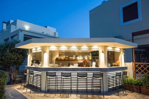 a restaurant with a bar in front of a building at Almiriki Chios Rooms & Apartments in Líthion