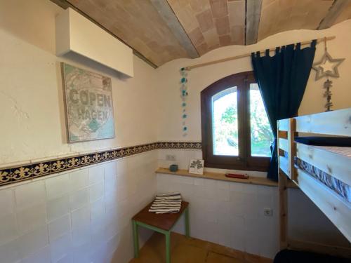 a bedroom with a bunk bed and a window at Santa Caterina - dog friendly with garden in Sobrestany