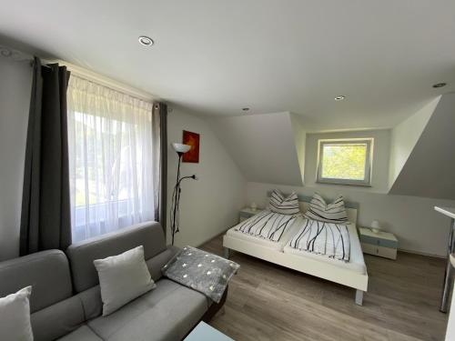 a bedroom with a bed and a couch at Ossiach Apartment 1 in Heiligen Gestade