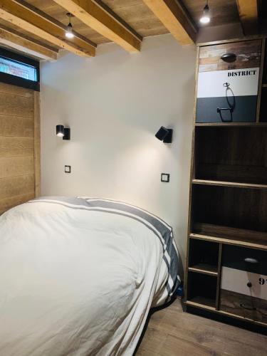 une chambre avec un lit et une étagère dans l'établissement duplex en plein centre d'Auron déco chalet cosy, à Saint-Étienne-de-Tinée