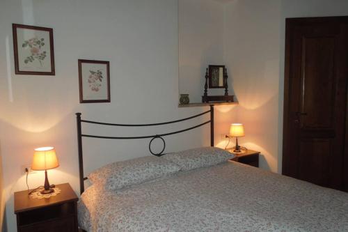 una camera da letto con un letto e due lampade sui tavoli di Appartamento Medievale San Pellegrino a Viterbo