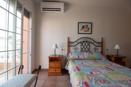 ein Schlafzimmer mit einem Bett und zwei Lampen und einem Fenster in der Unterkunft Villa Javi in Riumar