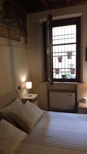a bedroom with a large bed and a window at AKANTHO apartment in Mantova