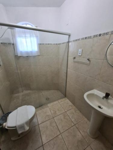 a bathroom with a shower and a toilet and a sink at VITORIA GARDEN in Águas de Lindóia