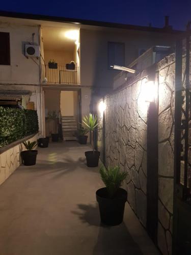 a courtyard with potted plants and lights on a building at TH LUXURY fly in Catania