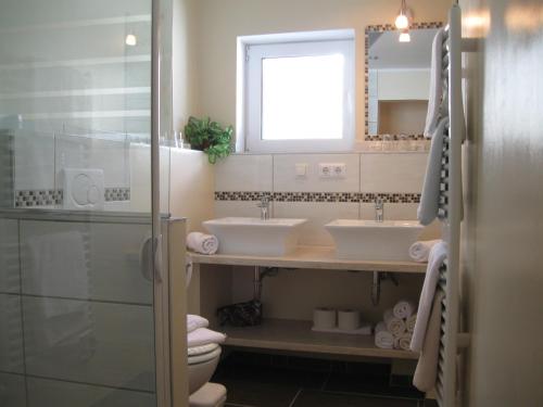 uma casa de banho com 2 lavatórios e um espelho em Appartements Schusser em Mallnitz