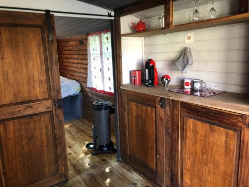 a kitchen with wooden cabinets and a bed in a room at La roulotte de Bussy in Bussières