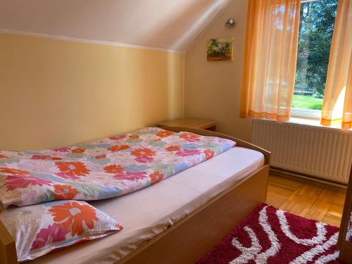 a bed sitting in a room with a window at Dusa Zlatibora in Zlatibor