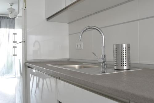 a kitchen with a sink in a white kitchen at El Encanto in Fuengirola