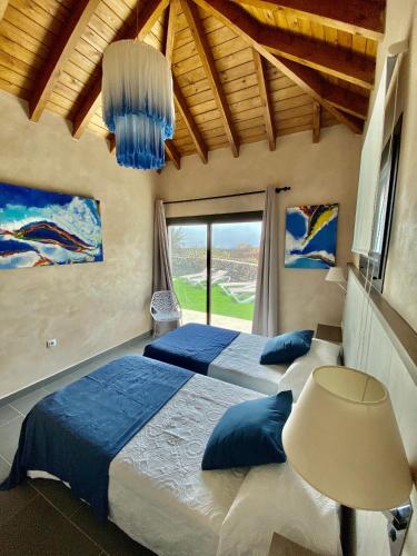 a bedroom with two beds and a large window at LA ERA 2 in El Cotillo