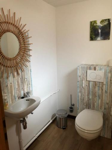 a bathroom with a sink and a toilet and a mirror at Haus Zissi in Burg-Reuland
